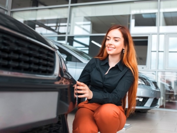 Woman Inspecting a Rental Car